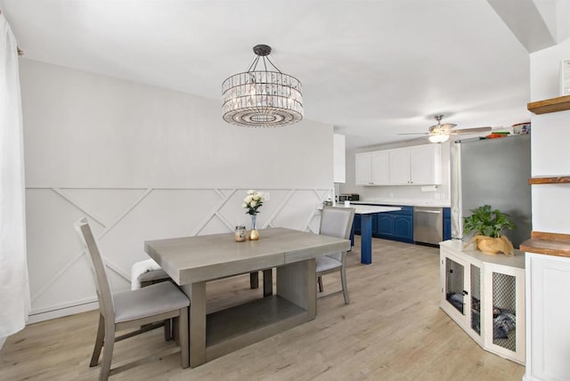 dining space featuring ceiling fan with notable chandelier and light hardwood / wood-style flooring