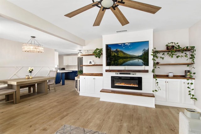 living room with ceiling fan and light hardwood / wood-style floors