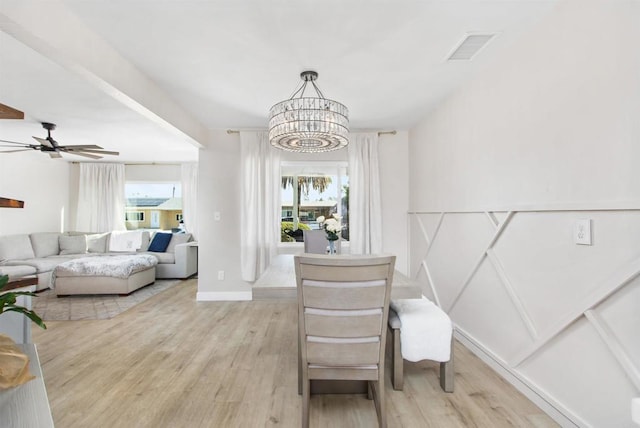 interior space featuring a healthy amount of sunlight, ceiling fan with notable chandelier, and light hardwood / wood-style flooring