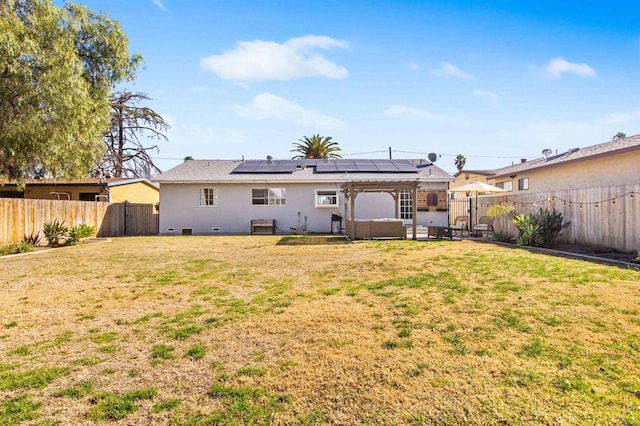 back of house with a lawn and solar panels