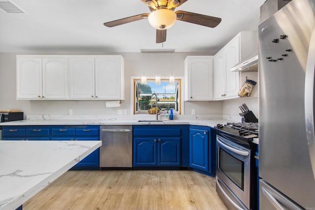 kitchen featuring sink, appliances with stainless steel finishes, white cabinetry, blue cabinets, and light wood-type flooring