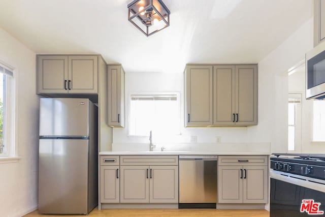 kitchen featuring sink, gray cabinets, stainless steel appliances, and light hardwood / wood-style floors