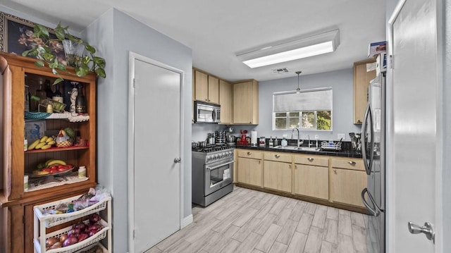 kitchen featuring stainless steel appliances, sink, light hardwood / wood-style flooring, and light brown cabinets