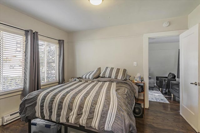 bedroom with dark hardwood / wood-style flooring and a baseboard radiator