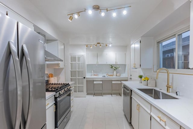 kitchen with white cabinetry, appliances with stainless steel finishes, sink, and backsplash