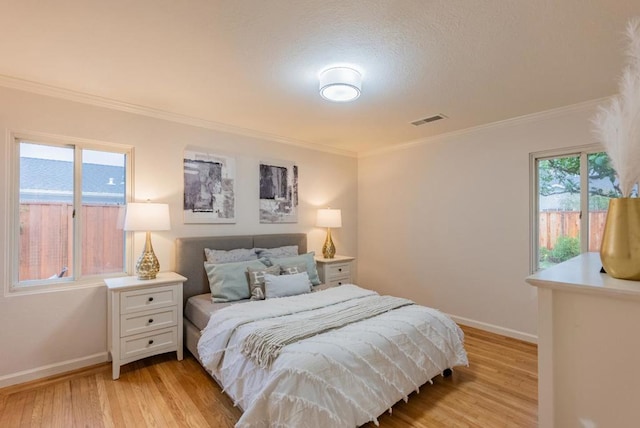 bedroom featuring ornamental molding and light hardwood / wood-style flooring