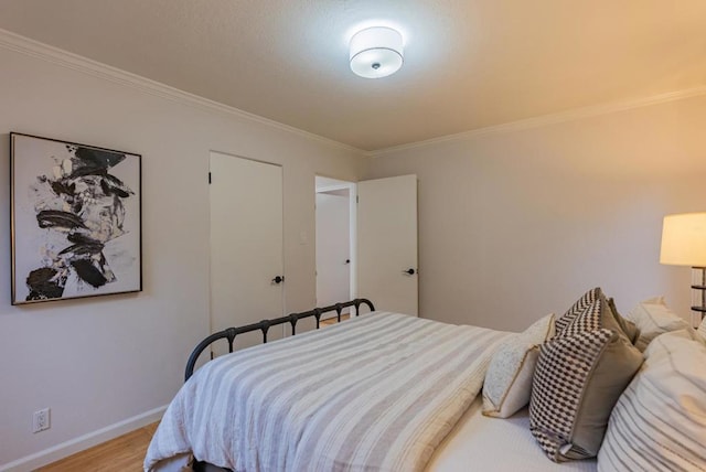 bedroom featuring crown molding and light hardwood / wood-style floors