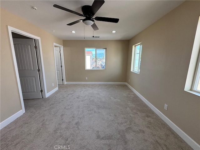 carpeted spare room with ceiling fan