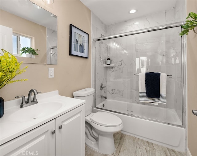 bathroom featuring toilet, shower / bath combination with glass door, recessed lighting, and vanity