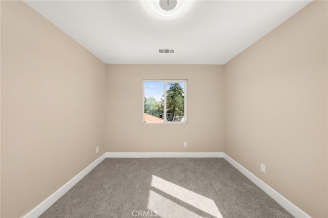 empty room with carpet floors, visible vents, and baseboards