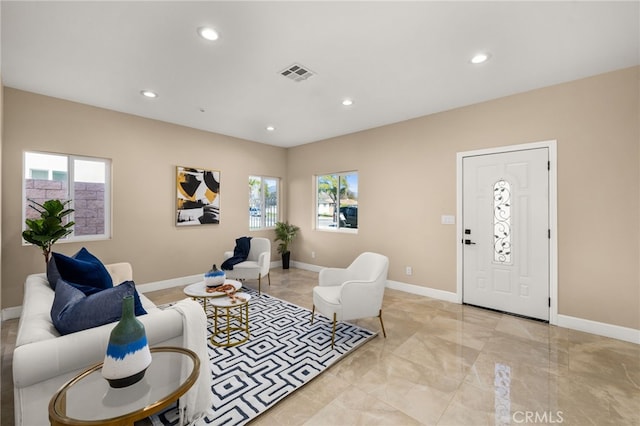 living area featuring plenty of natural light, visible vents, and baseboards