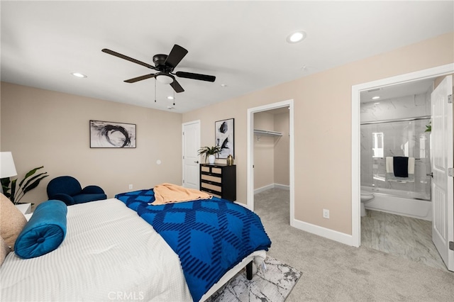 bedroom with a walk in closet, recessed lighting, light colored carpet, ceiling fan, and baseboards