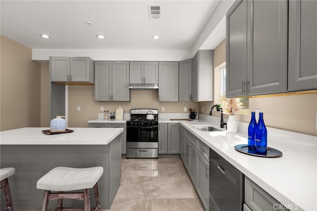 kitchen with visible vents, appliances with stainless steel finishes, gray cabinetry, under cabinet range hood, and a sink