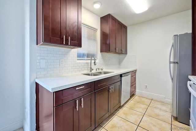 kitchen with sink, backsplash, light tile patterned floors, and appliances with stainless steel finishes