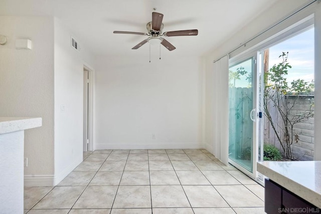 tiled spare room featuring ceiling fan