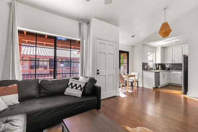 living room featuring dark wood-type flooring and vaulted ceiling