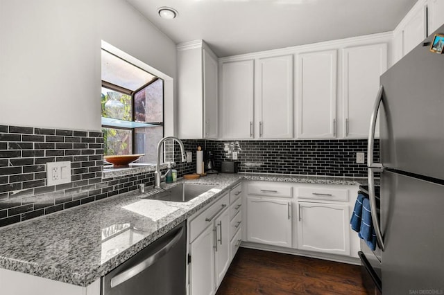 kitchen with white cabinetry, sink, light stone countertops, and appliances with stainless steel finishes