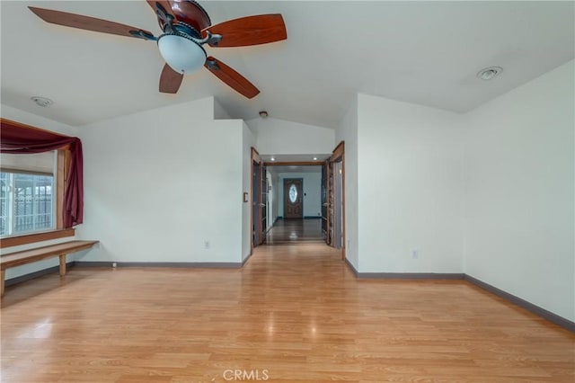 empty room with vaulted ceiling and light hardwood / wood-style flooring