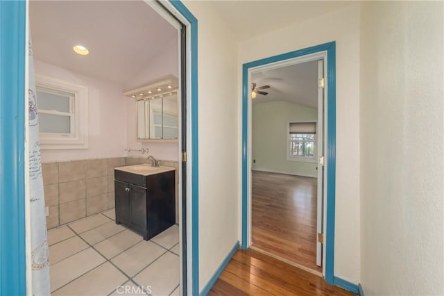 bathroom featuring hardwood / wood-style flooring, vanity, and lofted ceiling