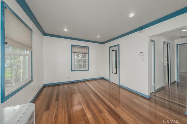 empty room featuring crown molding and dark hardwood / wood-style floors