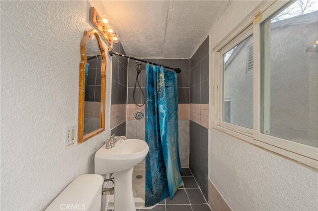 bathroom with tile patterned flooring, toilet, sink, and walk in shower