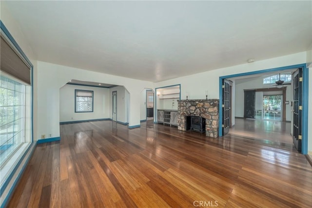 unfurnished living room with plenty of natural light, a fireplace, and wood-type flooring