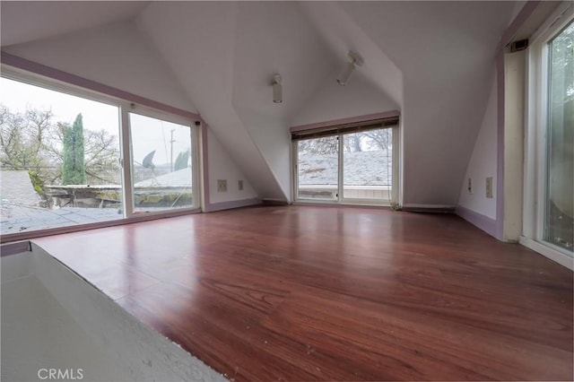 bonus room featuring vaulted ceiling and dark wood-type flooring