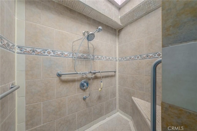 bathroom with tiled shower and a skylight