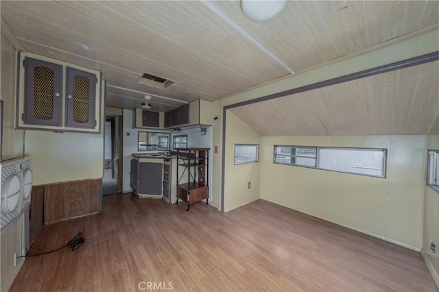 unfurnished living room featuring vaulted ceiling, hardwood / wood-style floors, and wood ceiling