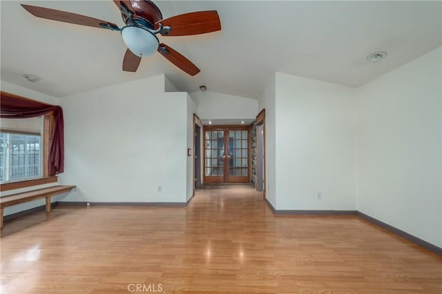 unfurnished room featuring french doors, lofted ceiling, ceiling fan, and light hardwood / wood-style flooring