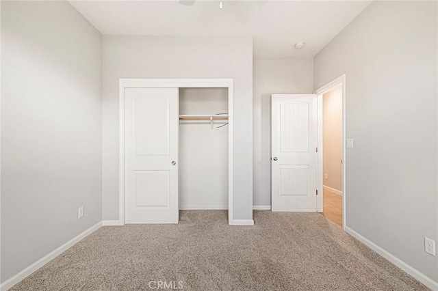 unfurnished bedroom featuring carpet flooring and a closet