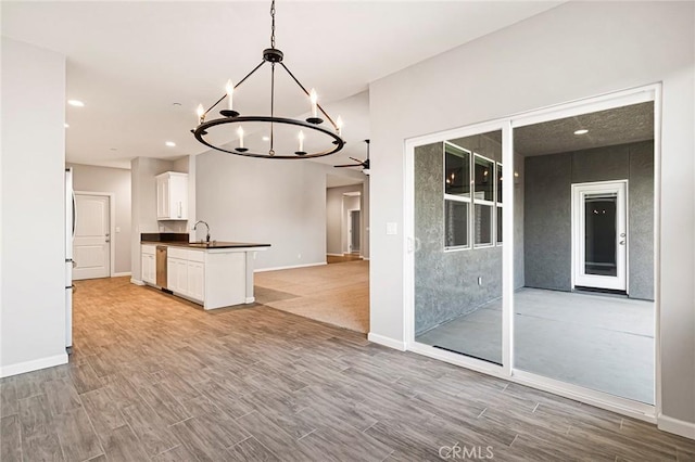 kitchen featuring a notable chandelier, light hardwood / wood-style flooring, white cabinets, and decorative light fixtures