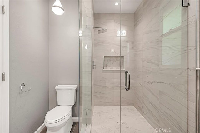 bathroom featuring toilet and a shower with shower door