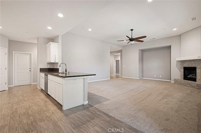 kitchen featuring sink, white cabinets, stainless steel dishwasher, ceiling fan, and light hardwood / wood-style floors