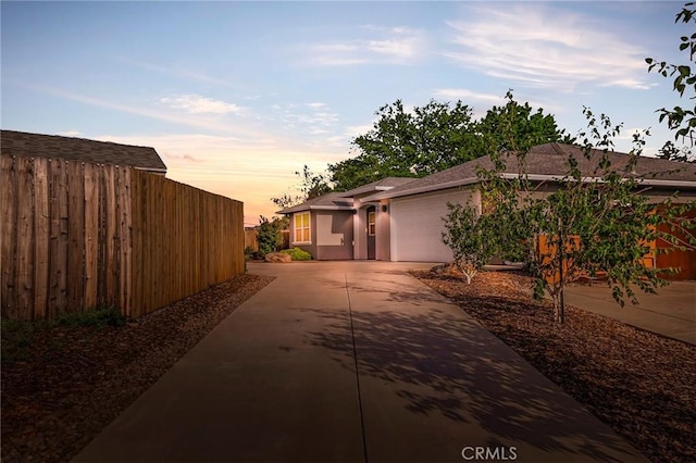 property exterior at dusk featuring a garage