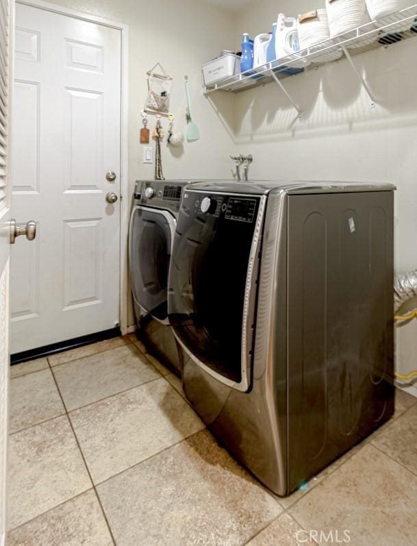 laundry area featuring washing machine and dryer and tile patterned floors