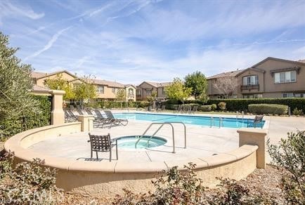 view of swimming pool featuring a hot tub