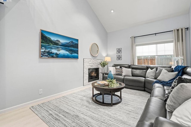 living room featuring high vaulted ceiling and light hardwood / wood-style flooring