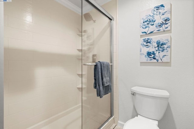 bathroom with ornamental molding, toilet, and an enclosed shower