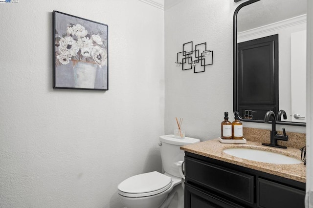 bathroom featuring vanity, crown molding, and toilet