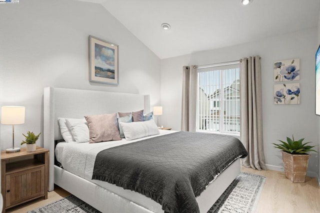 bedroom featuring vaulted ceiling and light hardwood / wood-style floors