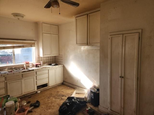 kitchen with stainless steel gas cooktop, tile countertops, ceiling fan, and decorative backsplash