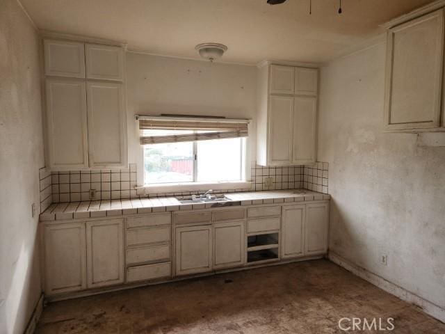 kitchen featuring tile counters, sink, and decorative backsplash