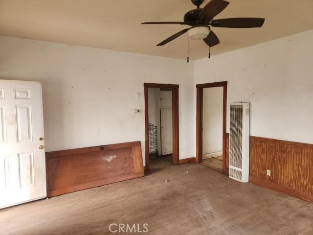 empty room with ceiling fan and wooden walls