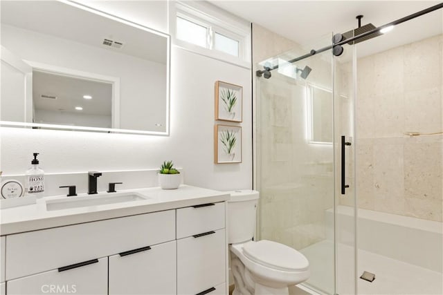 bathroom with walk in shower, vanity, and toilet