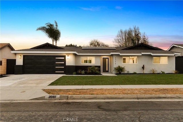 ranch-style house featuring a yard and a garage