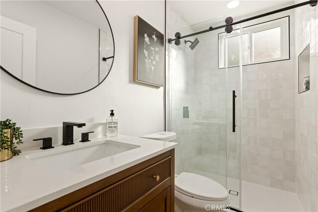 bathroom with vanity, an enclosed shower, and toilet