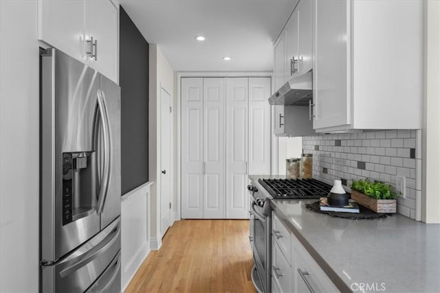 kitchen with white cabinetry, tasteful backsplash, stainless steel appliances, and light wood-type flooring