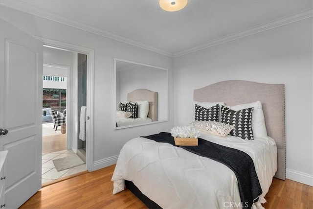 bedroom with crown molding, wood finished floors, and baseboards