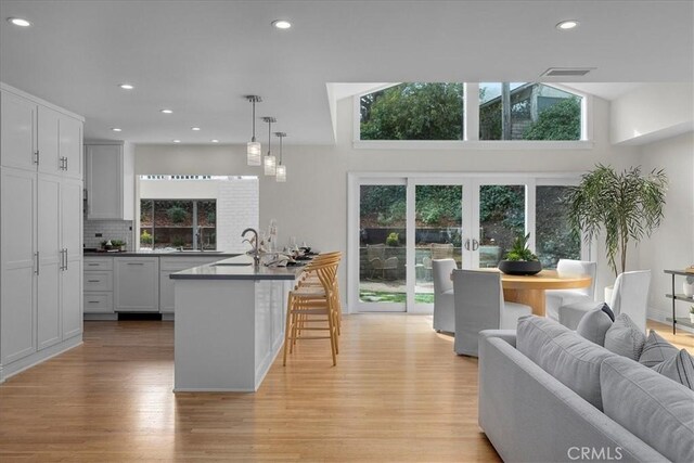 kitchen featuring dark countertops, a kitchen breakfast bar, light wood-style floors, and open floor plan